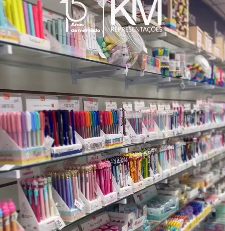 Prateleiras de papelaria da KM² com canetas, lápis e material de volta às aulas